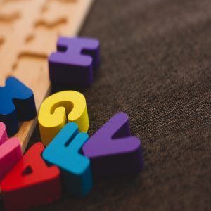 A colorful block letter puzzle scattered on the ground