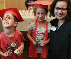 Library staff member with two "1000 Books Before Kindergarten" graduates