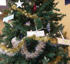 Gift tags displayed on a decorated tree