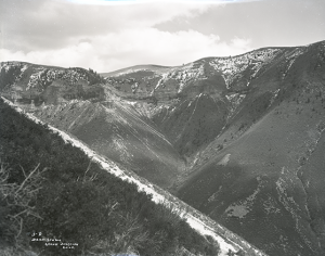 Photo from the 1920s depicting tall cliffs containing oil shale, possibly near Parachute, Colorado.