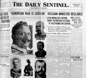 ID: Newspaper clipping of the front page of The Daily Sentinel dated to July 27, 1914, on the eve of the first World War. Headlines include "EUROPEAN WAR IS CERTAIN, RUSSIAN MINISTER DECLARES" and "CZAR MOBILIZES ENTIRE ARMY TO PREVENT ATTACK OF AUSTRIANS ON SERBIA." Included are portraits of several European leaders, including Kaiser Wilhelm the Second of Germany, King Victor Emmanuel the Third of Italy, King George the Fourth of England, Czar Nicholas the Second of Russia, President Raymond Poincaré of France, and Emperor Franz Josef of Austria-Hungary.
