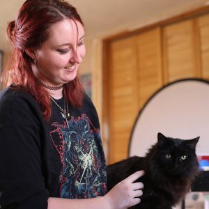 Artist Hannah Martin pets a cat
