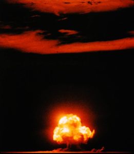Photo I.D. - Color photograph depicting a glowing mushroom cloud, the result of the Trinity nuclear test.
