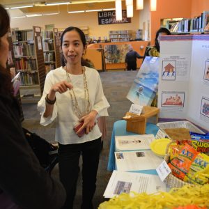 Two people standing near a Philippines information table
