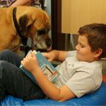 Child reading to a dog at the library