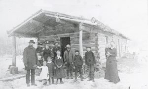 Photo depicting John Hurlburt and his family in front of their homestead near Parachute Creek.