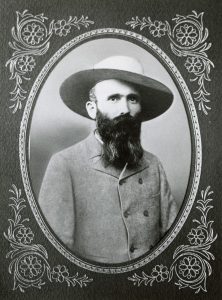 Photo of Doctor Wallace de Beque, donning a hat and possessing a long beard. 