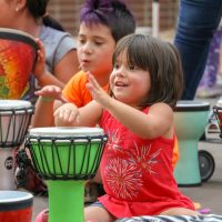 small child playing a hand drum
