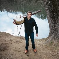 a person holding a kora musical instrument